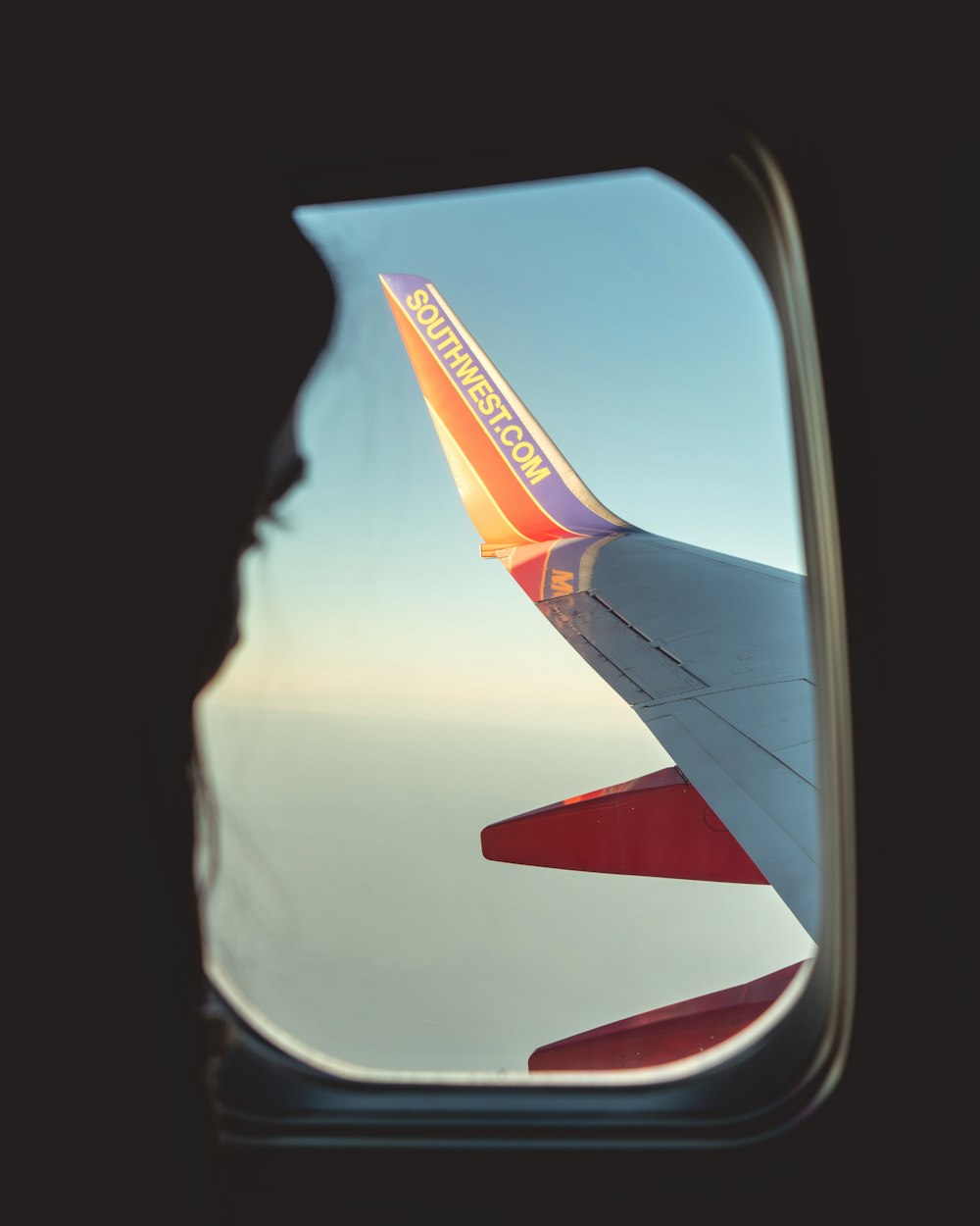 Silhouette einer Person, die den Flügel des Verkehrsflugzeugs betrachtet