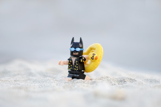 LEGO Batman figurine on white sand at daytime in Bengkulu Indonesia