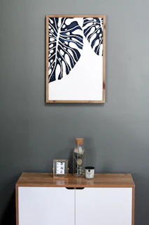 a picture hanging on a wall above a dresser