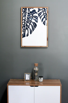 a picture hanging on a wall above a dresser