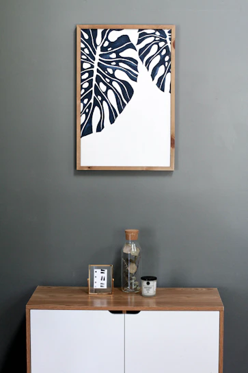 a picture hanging on a wall above a dresser