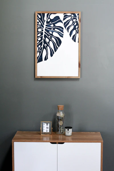 a picture hanging on a wall above a dresser
