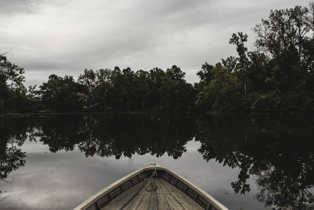 brown boat on body of water near green-leafed trees