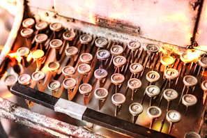 A vintage typewriter with a glowing red key in a cozy newsroom.