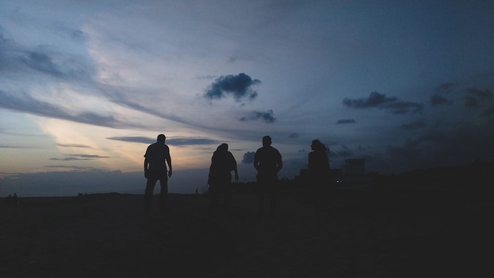 silhouette of four people during sunset