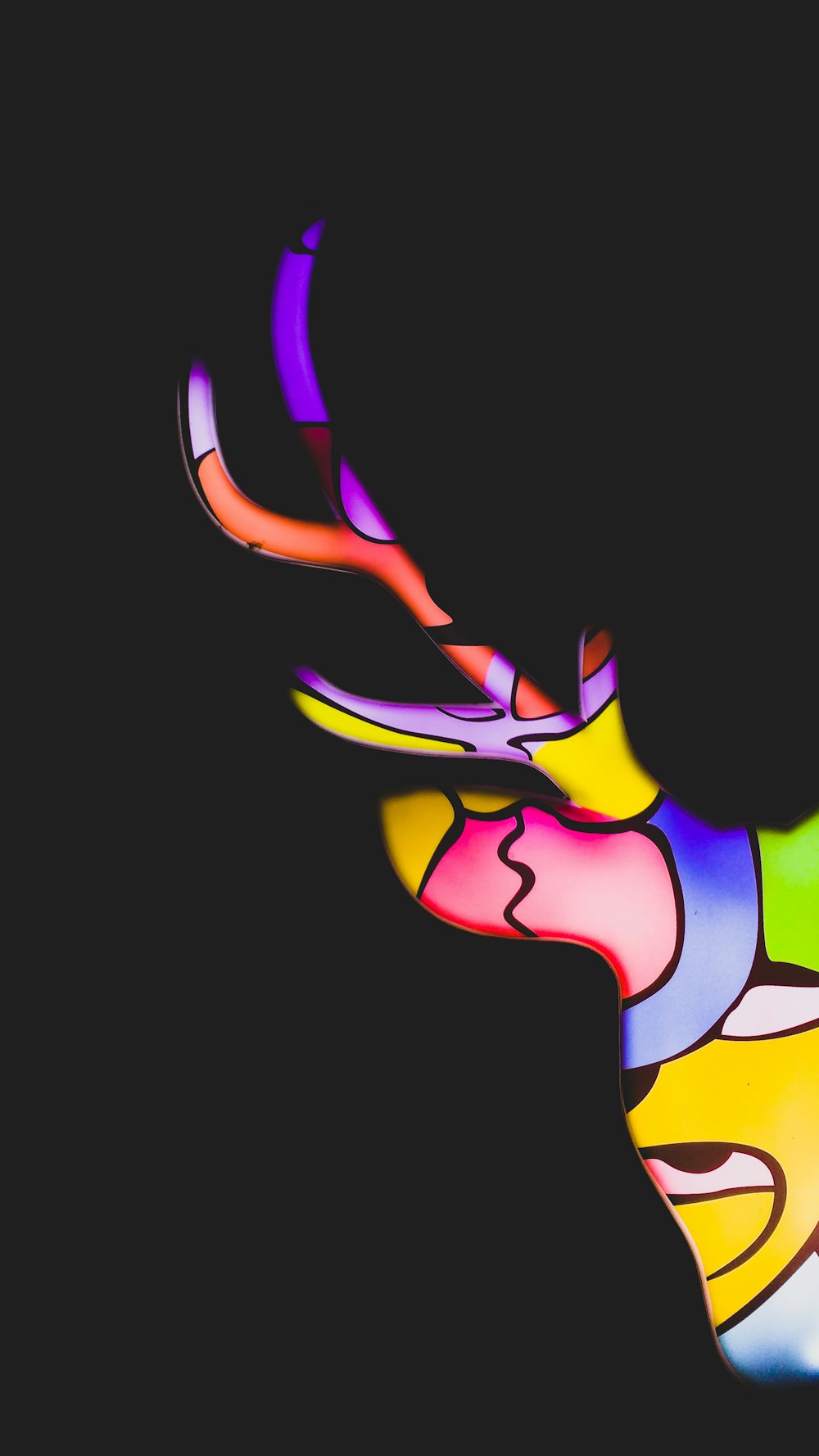une tête de cerf multicolore sur fond noir