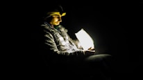 A person comfortably wearing the iRestore helmet while reading a book at home.