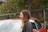 A happy customer standing next to her car at Check-Up Car.