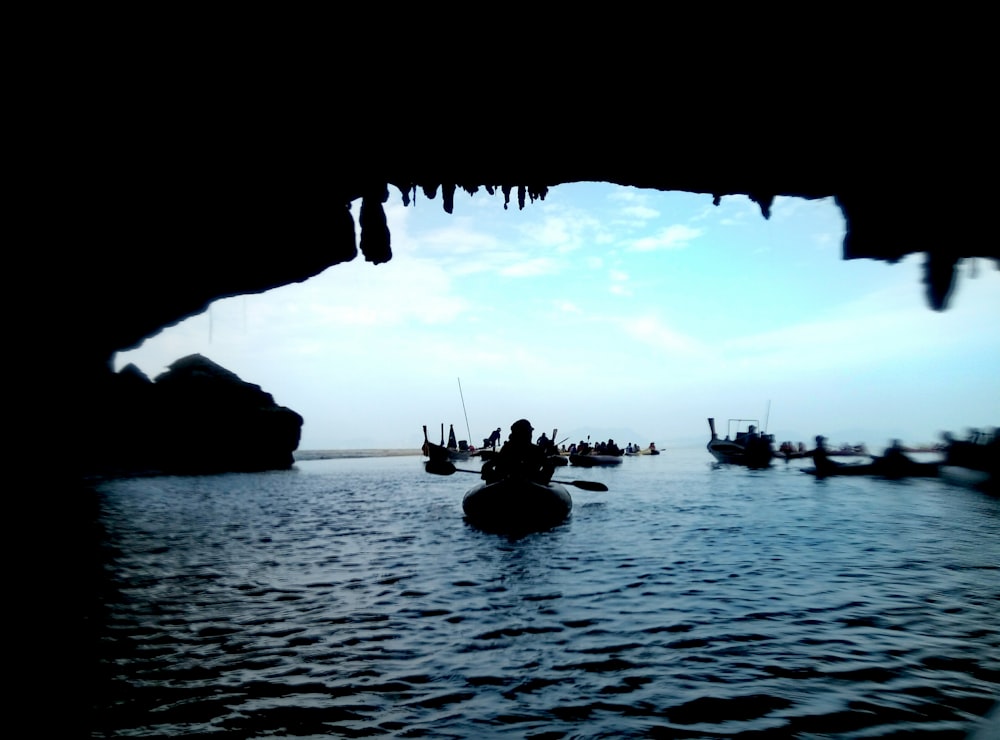 silhouette of boat inside cave