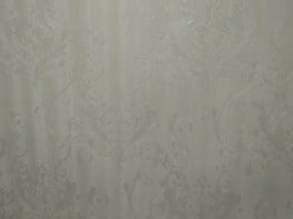 A detailed shot of a hand-painted accent wall with textured wallpaper in neutral tones.