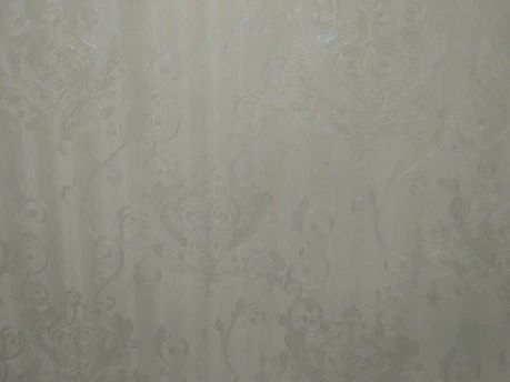 A close-up of a stylish wall covered with textured wallpaper in a modern living room.