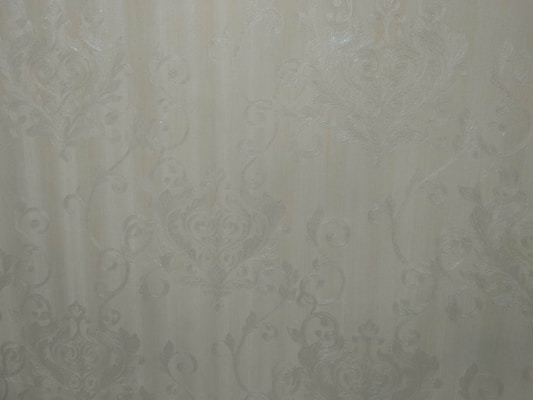 Close-up of vibrant floral wallpaper with delicate petals and leaves in soft pastel tones.