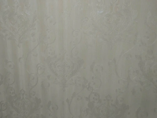 Close-up of a bespoke wallpaper pattern blending warm greys and beige tones with architectural lines.