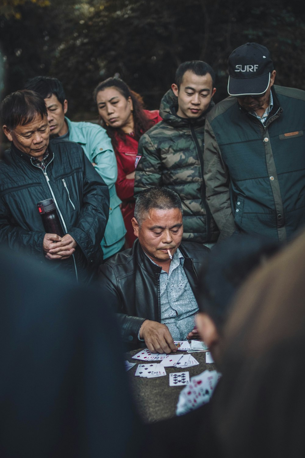 man sitting on chair while playing card