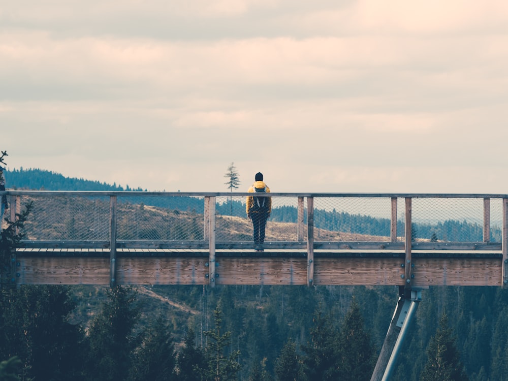 person standing in the middle of the bridge