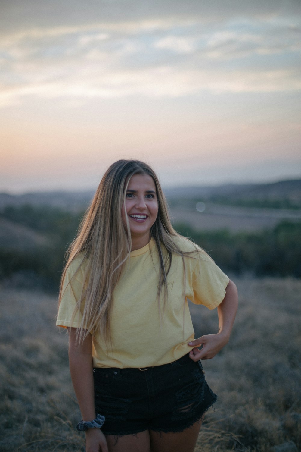 woman wearing yellow shirt and black shorts at the field