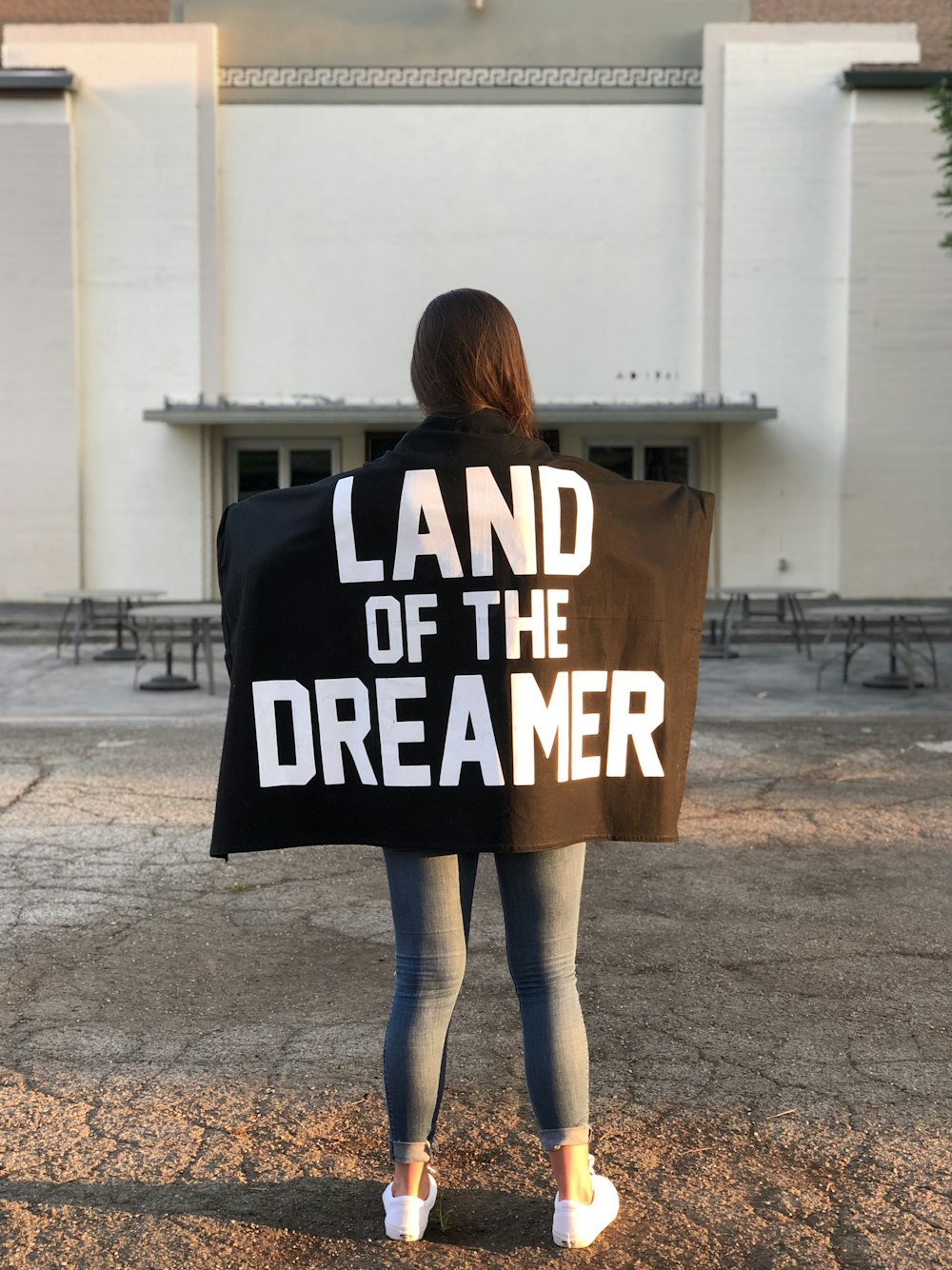 person holding black textile with land of the Dreamer text