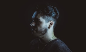 Side view of a man with a neat, classic haircut and trimmed beard.