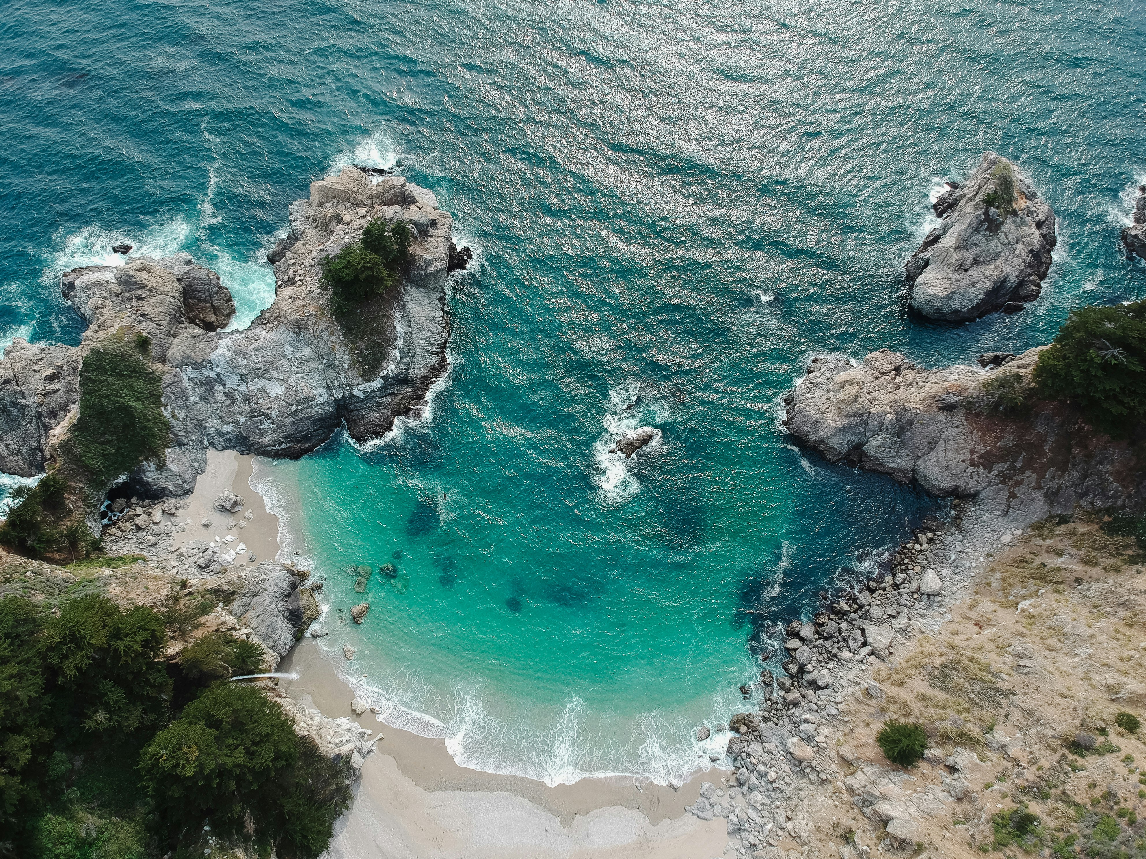 aerial view of beach with rock mountain during daytime