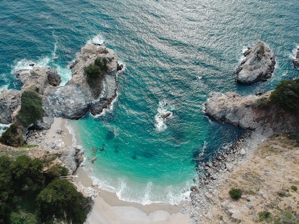 Vista aérea de la playa con la montaña de roca durante el día