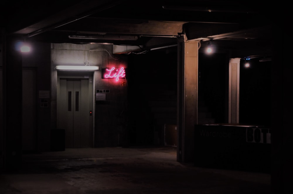 turned-on pink neon sign beside door