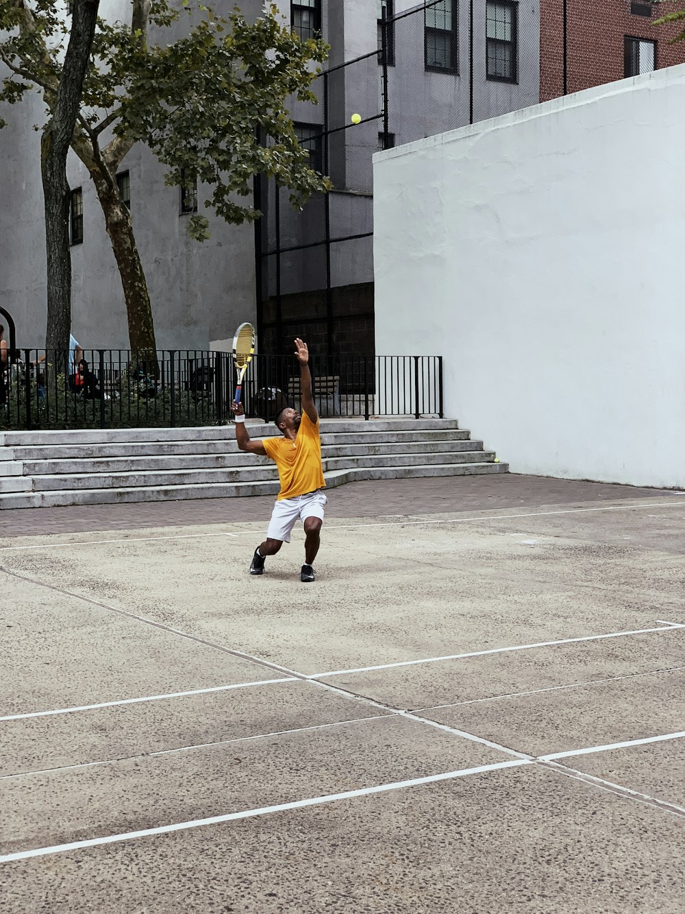 man wearing yellow shirt playing tennis