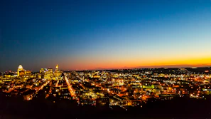 Abstract city skyline at dusk with illuminated windows in warm orange and gold tones.