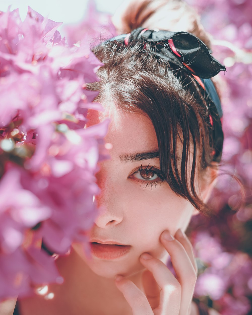 Mujer escondida en flores de pétalos rosados