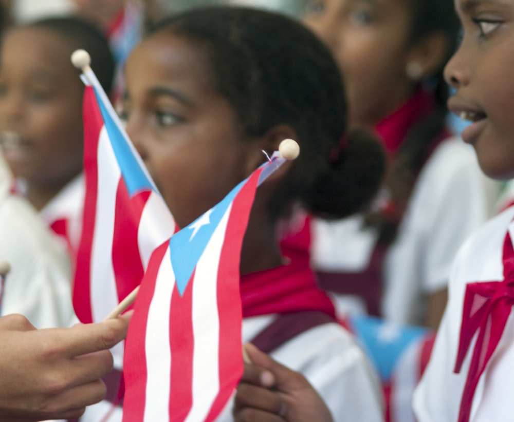 selective focus photography of boy holding flag