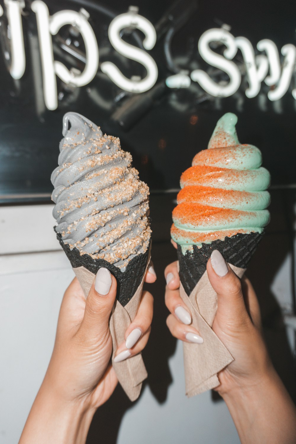 two assorted-flavor ice cream in cones