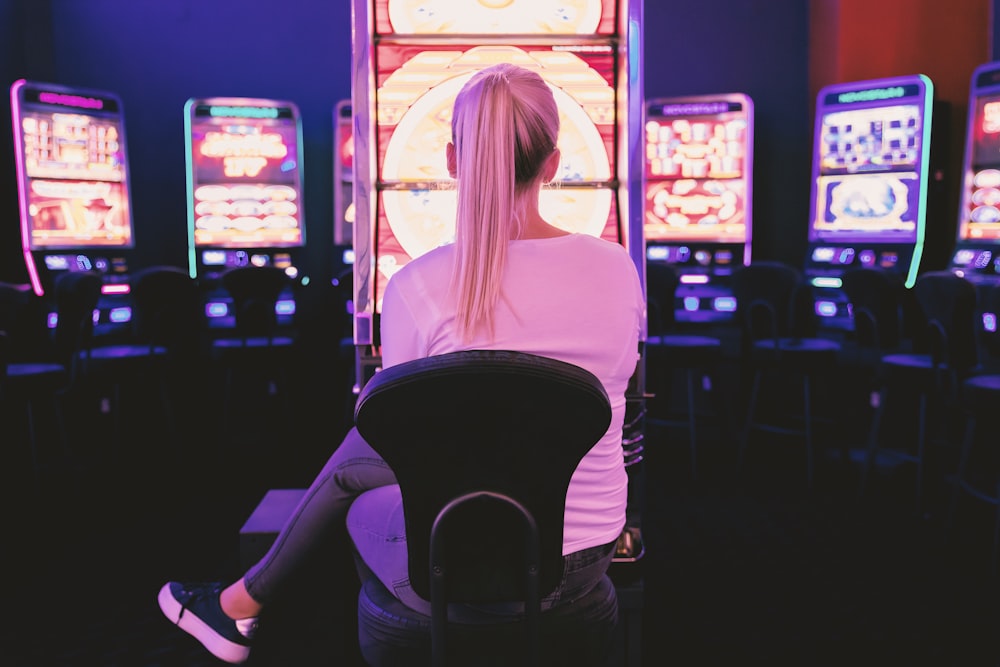 mulher sentada de frente para a máquina de arcade