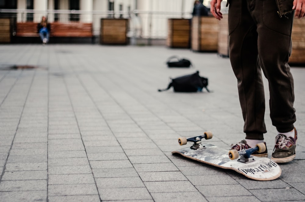 person standing near white and black skateboard