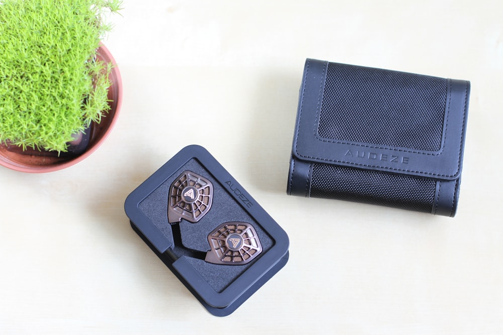 a pair of cufflinkers sitting next to a potted plant