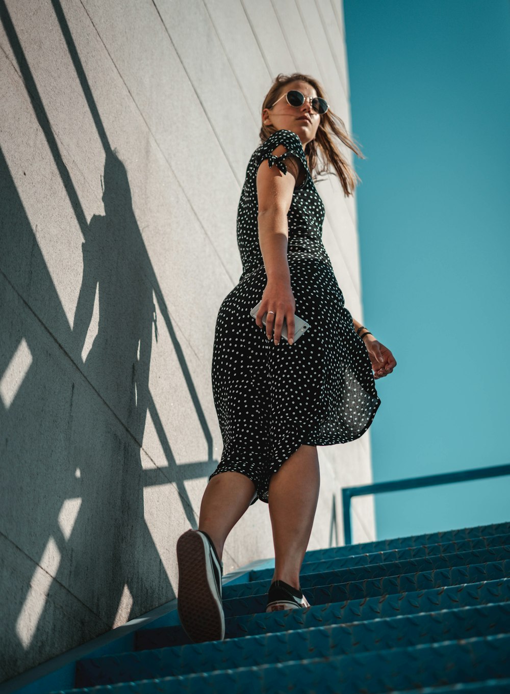 woman holding smartphone wearing black dress