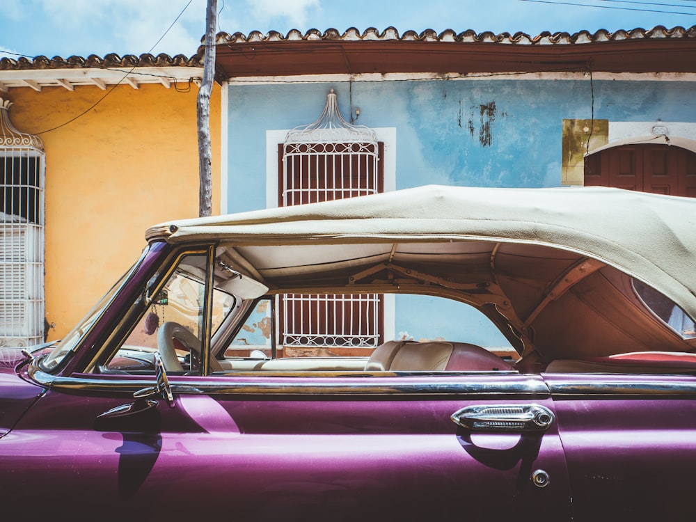 purple car near blue and yellow building