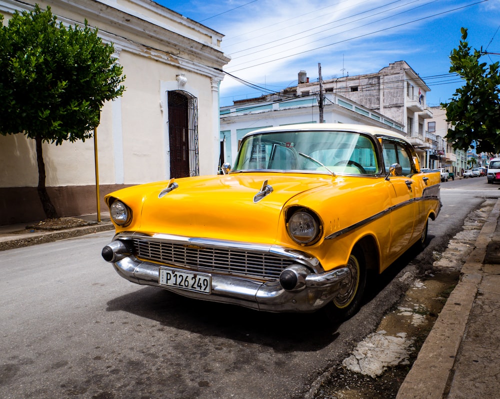 orange classic vehicle park on road