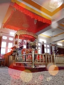 Traditional kına tahtı setup with rich red fabrics and intricate gold details