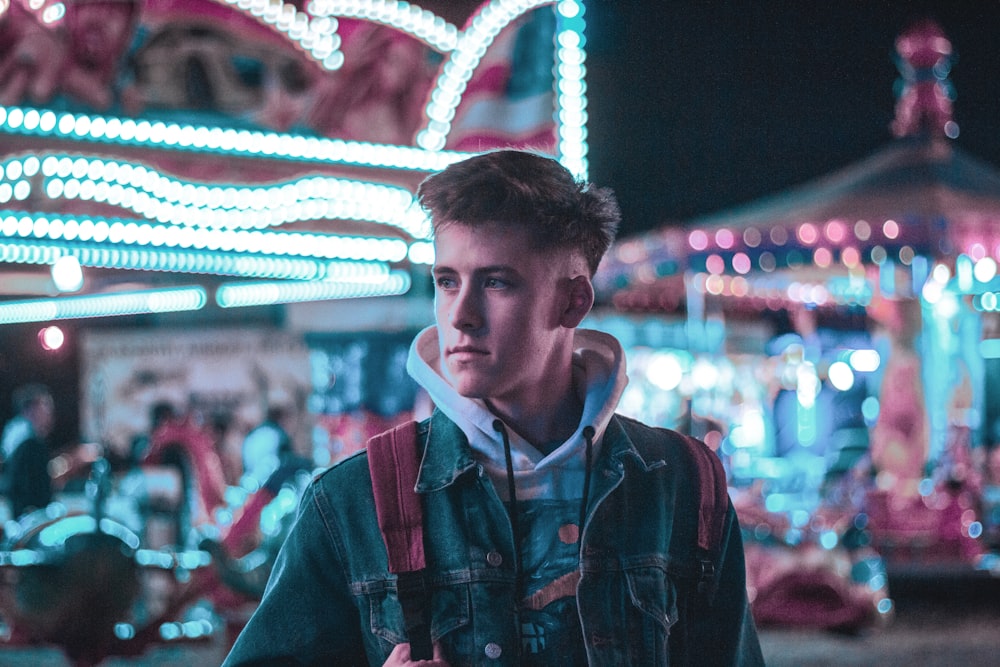 bokeh photography of man standing inside amusement park