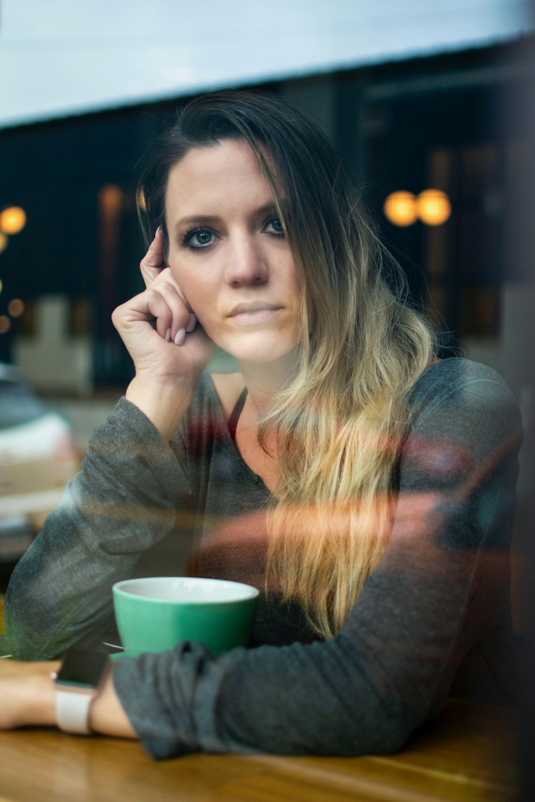 woman in gray long-sleeved top sitting on chair