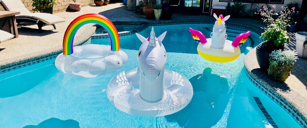 three inflatable swim rings on swimming pool during daytime