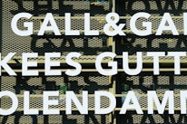 Large white letters spell out 'GALL&GALL' and 'KEES GUTT' against a perforated metal background. The letters appear to be part of an outdoor sign or billboard.