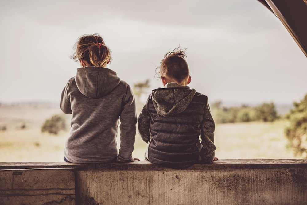 two toddlers setting on table