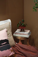 A cozy, modern wellness corner with neutral tones and a small plant beside a stack of health books.