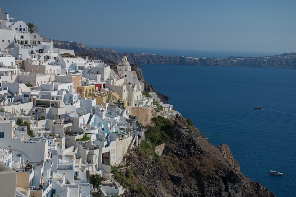 a boat is in the water near a white village