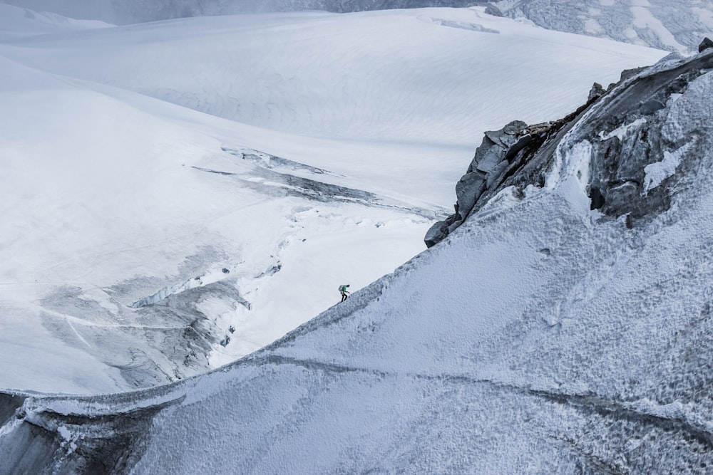 person climbing on top of mountain