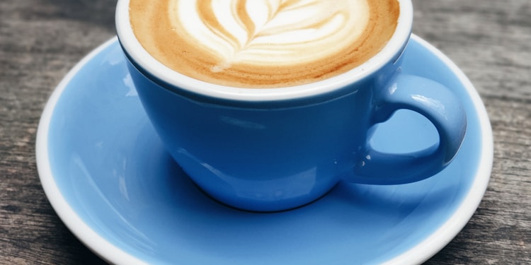 blue ceramic teacup with latte