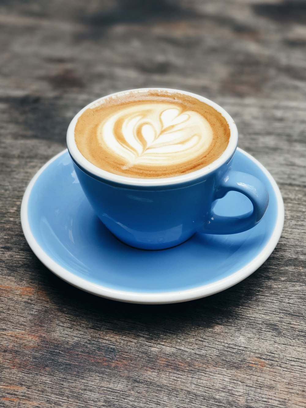 Teetasse aus blauer Keramik mit Milchkaffee