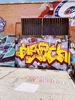 A bold, graffiti-style mural that reads 'I Hate Ian' in vibrant colors on a brick wall.
