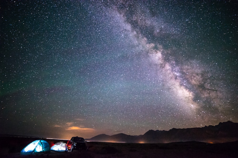 two blue tents under night skies with milky way