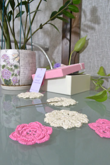 Close-up of a delicate beige crochet flower resting on a wooden table.
